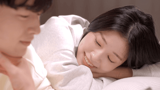 Smiling couple resting together on bed