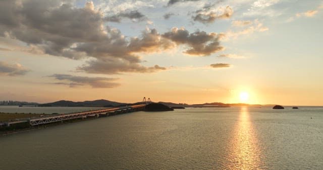 Sunset over a bridge and calm sea