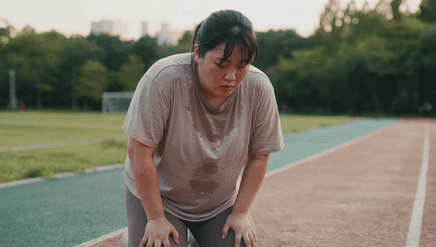 Fat woman catching her breath after jogging