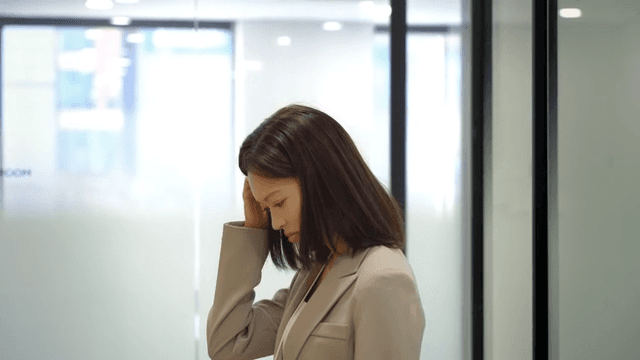 Female office worker lost in thought as she leaves meeting room