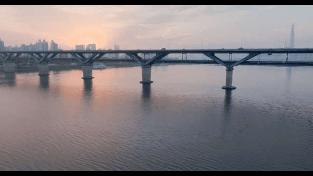 다리와 도시 스카이라인 위의 일몰