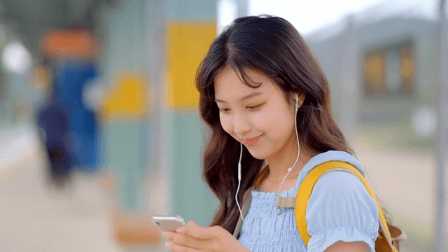 역에서 음악을 듣는 젊은 여성