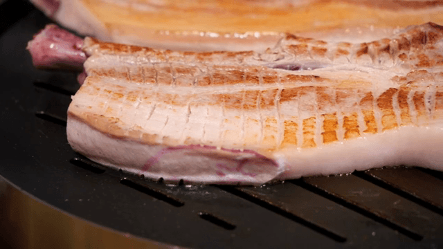 Grilling pork belly on a hot grill