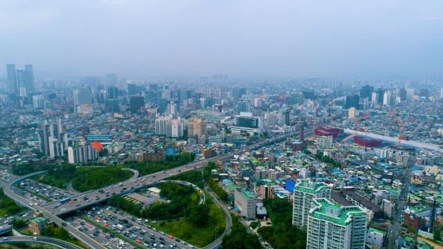 Overcast Day, Bustling Cityscape with Traffic and Buildings