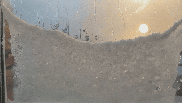 햇빛이 비치는 눈 덮인 창문