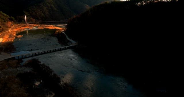 산악 현수교 위로 지는 석양