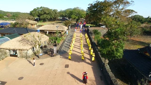 People wearing Hanbok and performing traditional cultural performances at a folk village