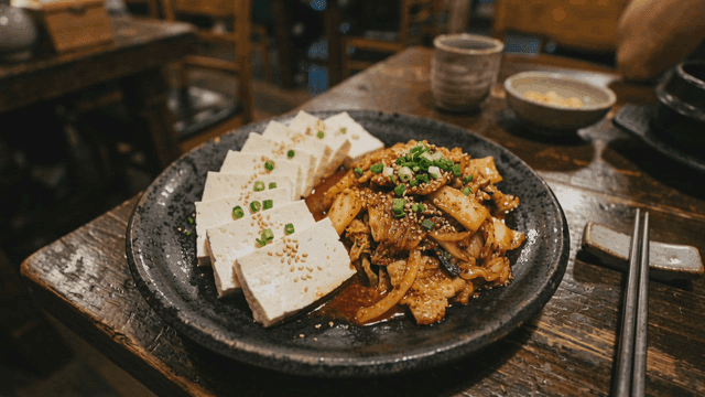 Plate containing tofu and spicy pork stir-fry