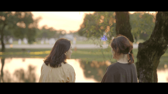 Two women talking by lake