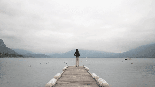 Back of woman standing on lakeside pier