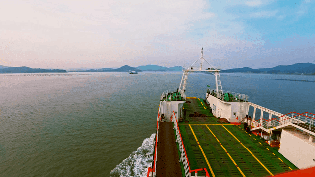 잔잔한 바다 위로 섬으로 항해하는 선박