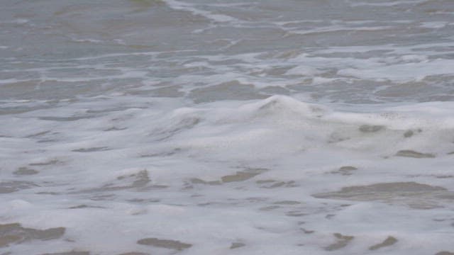 Waves Washing Ashore on a Sandy Beach