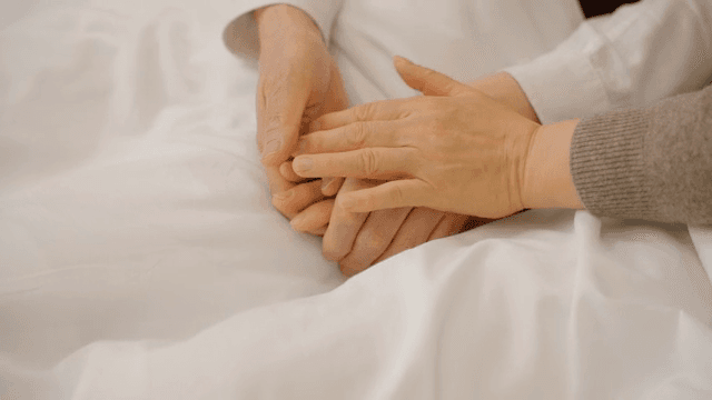 침대에서 손을 잡고 있는 두 사람