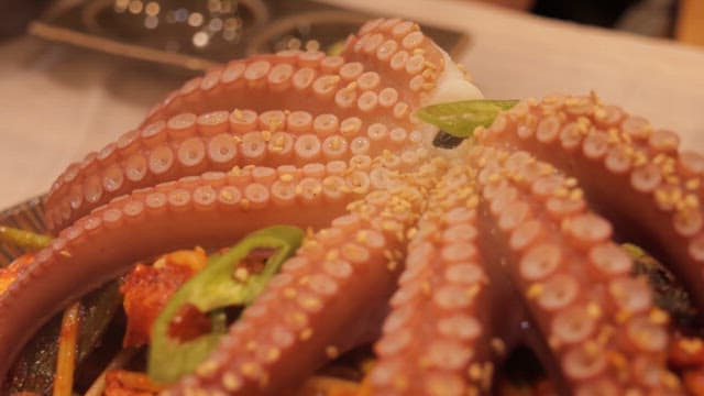 Braised spicy seafood topped with a large octopus