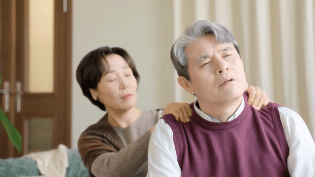 남성의 어깨를 안마하는 여성