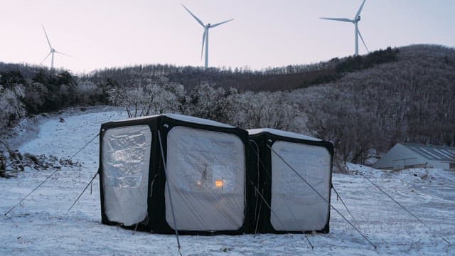 Cozy illuminated tent in snowy landscape