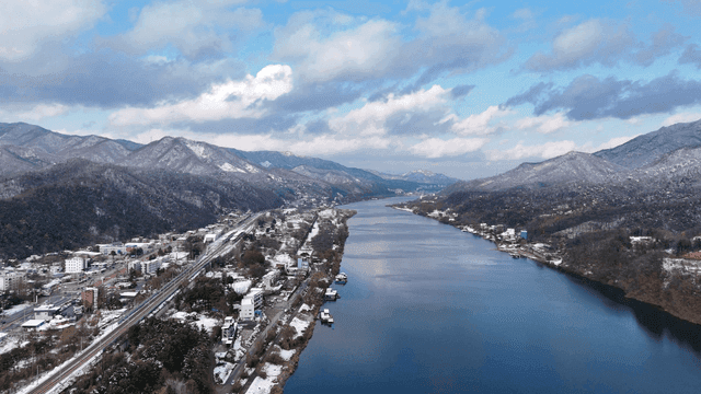 Snow-covered river flowing through mountain village