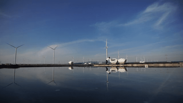 물가의 풍력 터빈과 사람