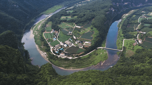Scenery of rural village surrounded by lush forests and winding rivers