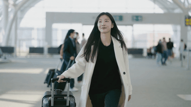 A woman walking with luggage at an airport