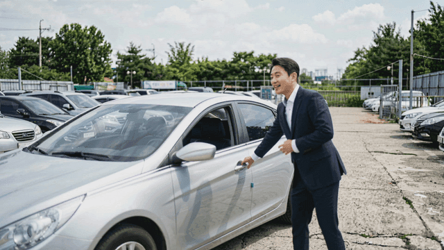 은색 세단을 보여주는 자동차 판매원