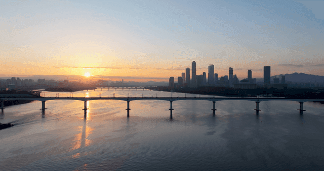 도시 스카이라인과 강 위로 떠오르는 일출