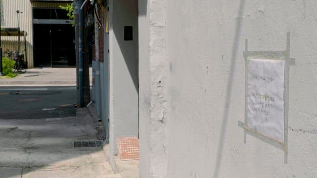벽에 공지가 붙은 좁은 골목