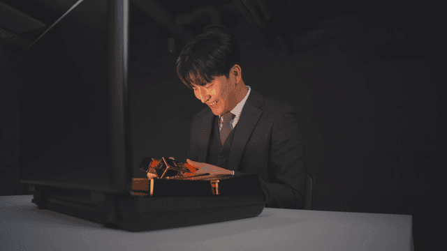 정장을 입은 남자가 금괴가 든 서류 가방을 여는 모습