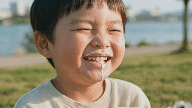 Boy drinking milk at riverside park