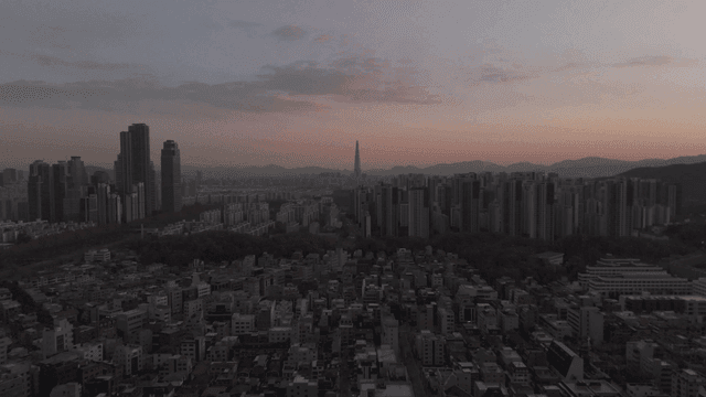 Panoramic view of city at dawn under pink sky