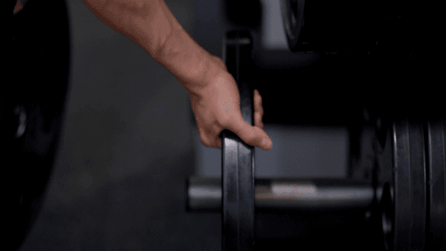 헬스장에서 무게 조절하는 남자