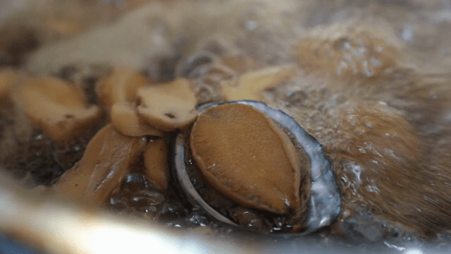 전복과 버섯이 국물에서 끓는 모습