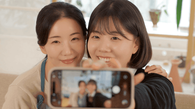 Mother and daughter taking selfies at home