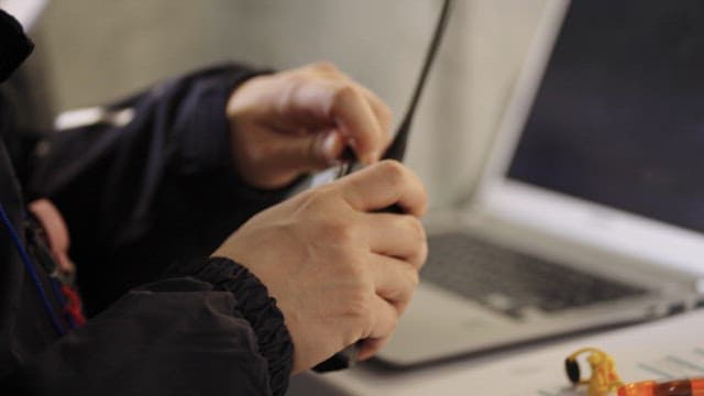 Hand Adjusting a Walkie-Talkie Channel