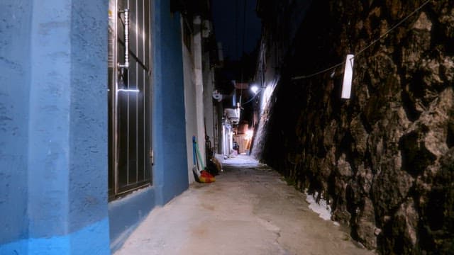 Narrow alleyway at night with dim lighting