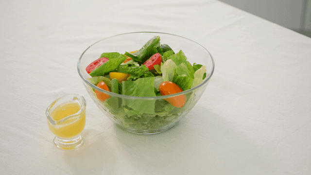 Fresh salad with dressing on a table