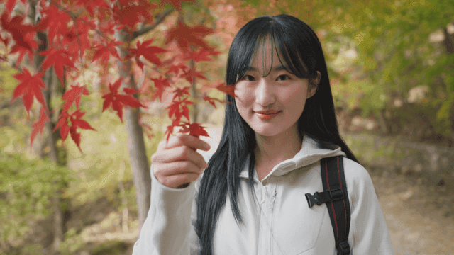 Young woman enjoying autumn foliage in forest