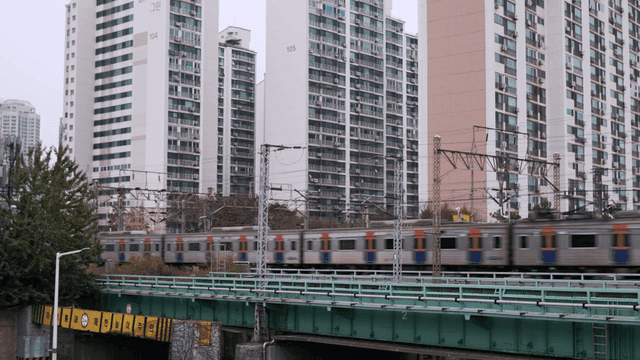 Train passing by high-rise apartment