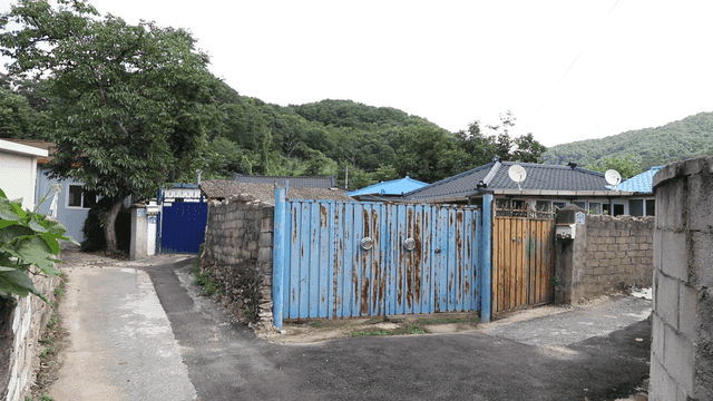 Quiet country village street with blue gate