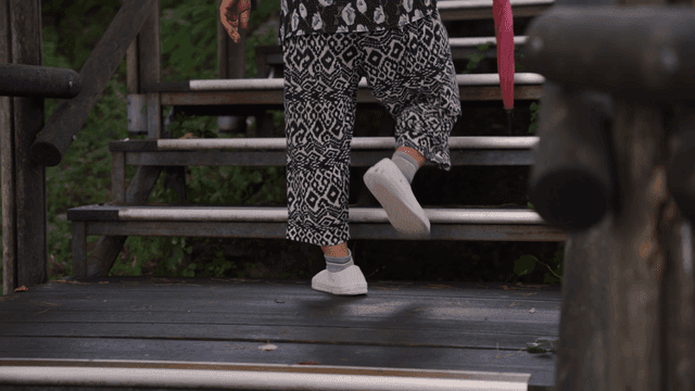An elderly person climbing outdoor stairs