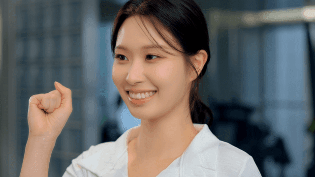 미소 지으며 주먹을 쥐고 응원하는 젊은 여성
