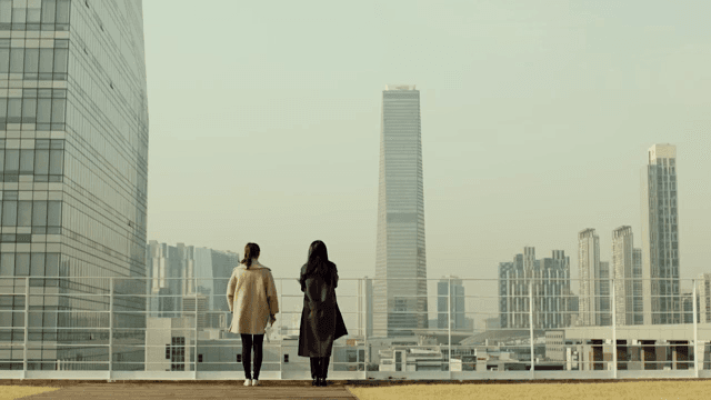 Back view of two women talking on the roof of a company