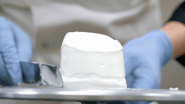 Layered cake with cream being decorated