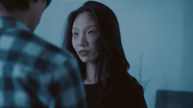 Woman with bruised face talking in living room