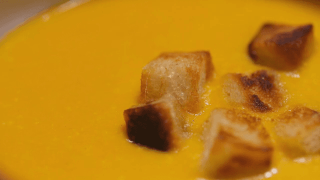 크루통이 올려진 노란 수프 한 그릇