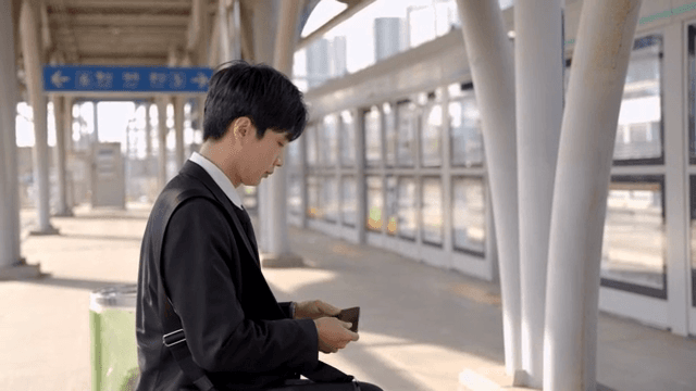 Office worker man sitting on a station chair waiting for the subway