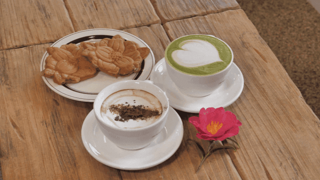 Cozy cafe table with latte coffee and camellia bread