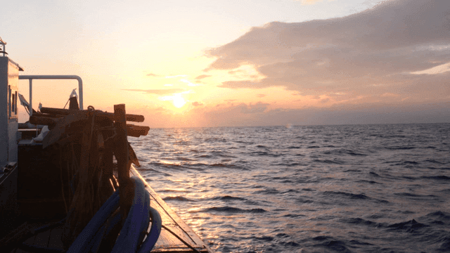 해 뜨는 바다와 배의 고요한 풍경