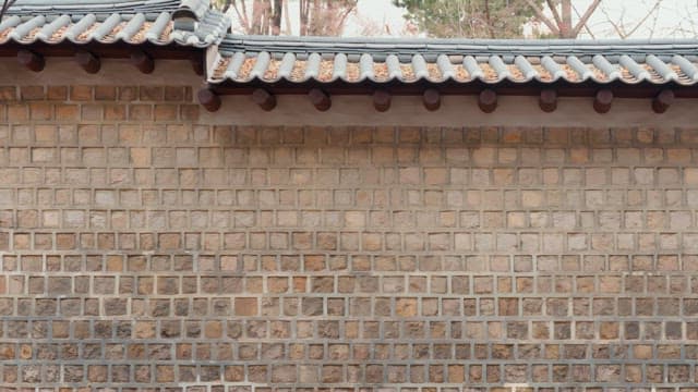 Traditional Korean wall with people passing by