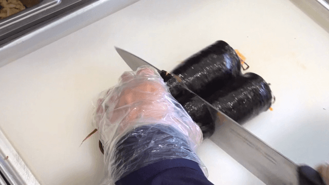 Slicing gimbap on a cutting board